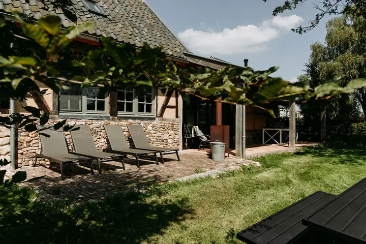 Vakantiehuisje 't Bakhuisje van vrouw Holle met ligstoelen in de tuin