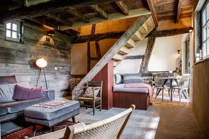 Woonkamer met eiken spanten in groepsaccommodatie Hoeve Hurpesch